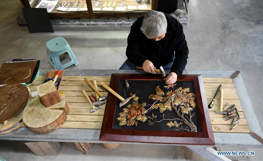 Guo Hailong, inheritor of welding-aided iron relief handicraft, works on an iron board at his workshop in Deming ancient town of Shijiazhuang, capital of north China\'s Hebei Province, on Dec. 4, 2018. The craftsmanship was listed as the provincial intangible cultural heritage in 2013. (Xinhua/Chen Qibao)