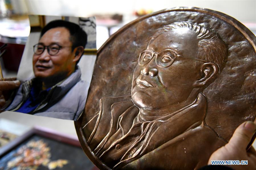 Guo Hailong, inheritor of welding-aided iron relief handicraft, checks a bust relief ordered by a customer at his workshop in Deming ancient town of Shijiazhuang, capital of north China\'s Hebei Province, on Dec. 4, 2018. The craftsmanship was listed as the provincial intangible cultural heritage in 2013. (Xinhua/Chen Qibao)