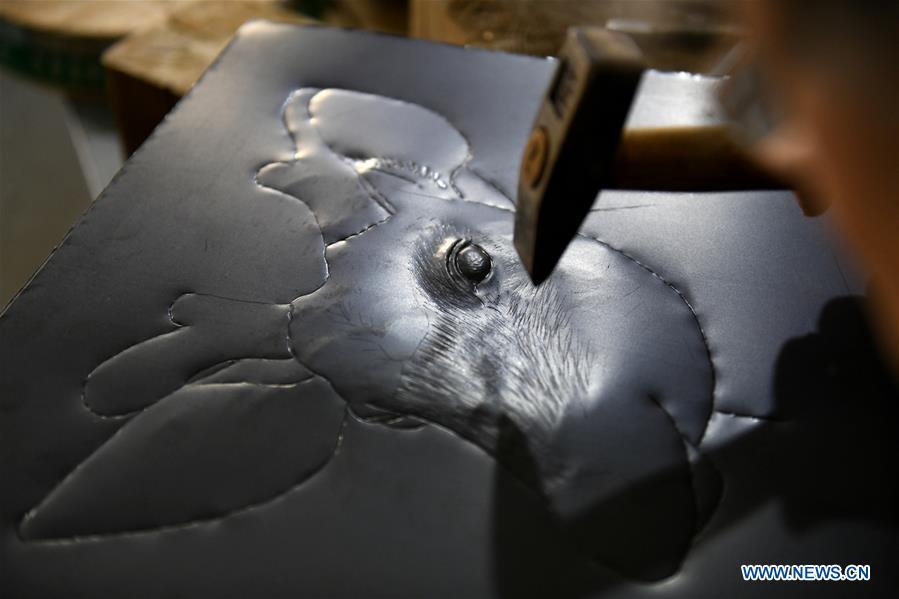 Guo Hailong, inheritor of welding-aided iron relief handicraft, works at his workshop in Deming ancient town of Shijiazhuang, capital of north China\'s Hebei Province, on Dec. 4, 2018. The craftsmanship was listed as the provincial intangible cultural heritage in 2013. (Xinhua/Chen Qibao)