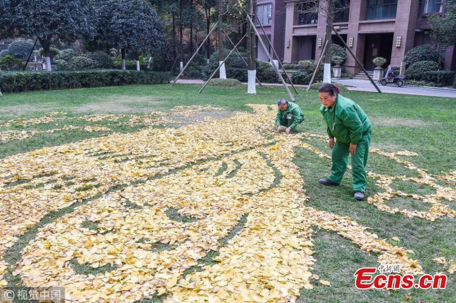 Sanitation workers collect fallen leaves and use them to form various patterns on ground in Qingyang district of Chengdu, Southwest China’s Sichuan province on December 4, 2018. (Photo/VCG)