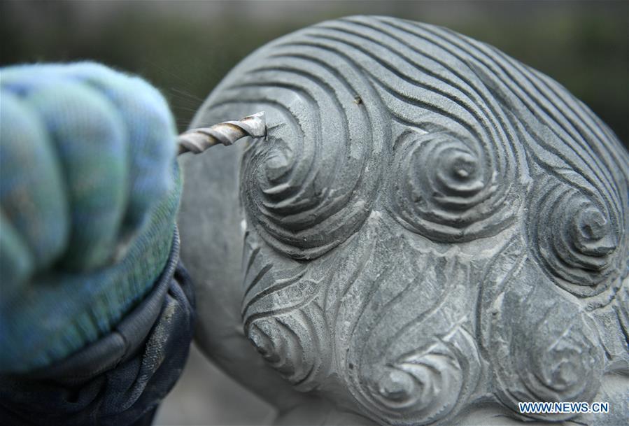 A handicraftsman processes a rock carving work in Longdong Village of Xuan\'en County in Enshi Tujia and Miao Autonomous Prefecture, central China\'s Hubei Province, Dec. 5, 2018. Residents here benefit from the rich rock resources and turn plain rocks into delicate artworks. (Xinhua/Song Wen)