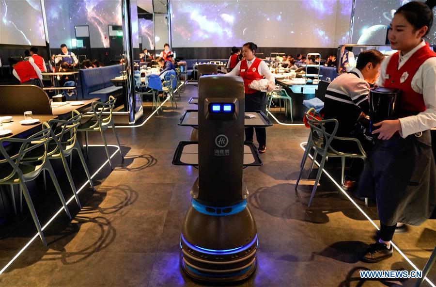 A delivery robot works at a hot pot restaurant in Beijing, capital of China, Dec. 5, 2018. A hot pot restaurant which integrates artificial intelligence, big data management and smart robot service has attracted lots of consumers. After customers order their dishes with a tablet computer, robotic arms in the kitchen get all dishes ready and then the delivery robots sent the dishes to the tables. Workers in the kitchen control all the procedures and also monitor the data for better management. (Xinhua/Chen Junqing)