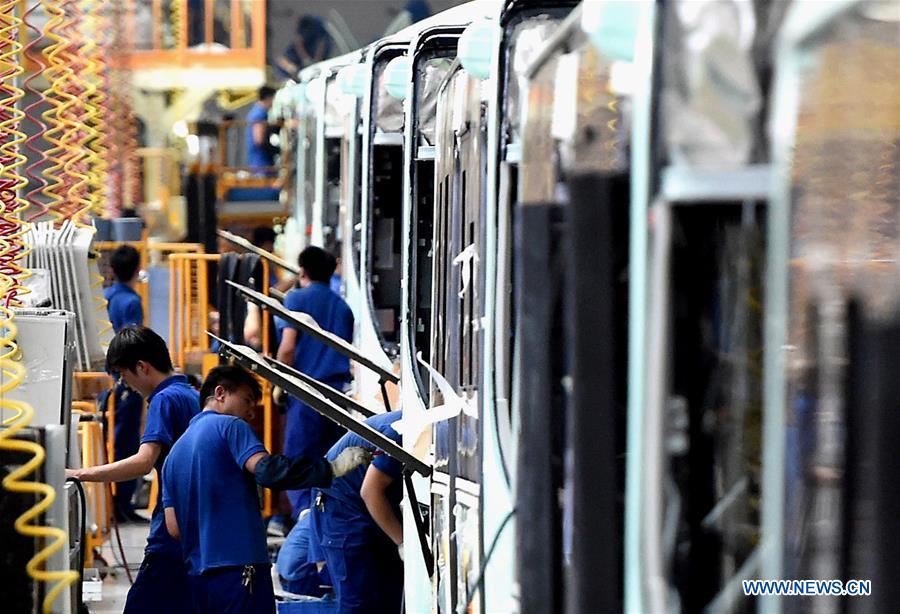 Staff members work on the production line of Yutong new energy bus in Zhengzhou, capital of central China\'s Henan Province, July 28, 2016. China has been delivering on its commitment to the international community on climate change by continuously shifting to a more green economy over the past years. New energy-rich regions like Inner Mongolia and Ningxia are sending more electricity generated from clean energy to the country\'s bustling east to help reduce the country\'s heavy reliance on coal in the fight against pollution and coping with climate change. China is also a leader in new energy vehicles (NEVs), with many regions across the country moving to replace their traditional gasoline-powered buses and taxis with green-energy vehicles. The country has been the world\'s largest NEV market for three consecutive years, with some 777,000 NEVs sold in 2017 alone. Sales in the first 10 months of this year jumped 75.6 percent year on year to 860,000 units. Thanks to increased investment in green energy, China\'s carbon intensity, or the amount of carbon dioxide emissions per unit of GDP, in 2017 had declined by 46 percent from 2005 levels, meeting the target ahead of schedule of a 40-45 percent drop by 2020, according to the Chinese Ministry of Ecology and Environment. (Xinhua/Li An)
