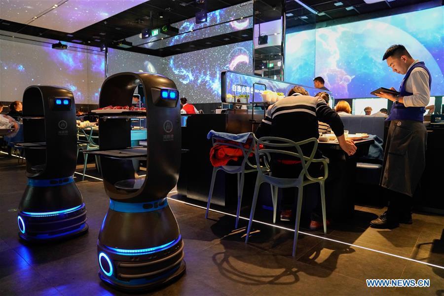 Delivery robots send dishes to tables at a hot pot restaurant in Beijing, capital of China, Dec. 5, 2018. A hot pot restaurant which integrates artificial intelligence, big data management and smart robot service has attracted lots of consumers. After customers order their dishes with a tablet computer, robotic arms in the kitchen get all dishes ready and then the delivery robots sent the dishes to the tables. Workers in the kitchen control all the procedures and also monitor the data for better management. (Xinhua/Chen Junqing)
