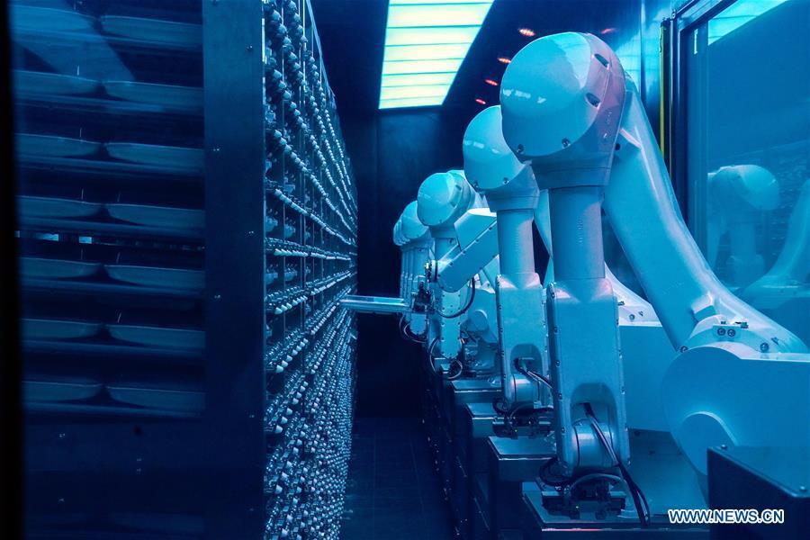 Robotic arms prepare dishes at a hot pot restaurant in Beijing, capital of China, Dec. 5, 2018. A hot pot restaurant which integrates artificial intelligence, big data management and smart robot service has attracted lots of consumers. After customers order their dishes with a tablet computer, robotic arms in the kitchen get all dishes ready and then the delivery robots sent the dishes to the tables. Workers in the kitchen control all the procedures and also monitor the data for better management. (Xinhua/Chen Junqing)