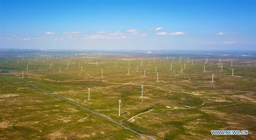 Aerial photo taken on Aug. 24, 2018 shows the Taiyangshan wind power station in the city of Wuzhong, northwest China\'s Ningxia Hui Autonomous Region. China has been delivering on its commitment to the international community on climate change by continuously shifting to a more green economy over the past years. New energy-rich regions like Inner Mongolia and Ningxia are sending more electricity generated from clean energy to the country\'s bustling east to help reduce the country\'s heavy reliance on coal in the fight against pollution and coping with climate change. China is also a leader in new energy vehicles (NEVs), with many regions across the country moving to replace their traditional gasoline-powered buses and taxis with green-energy vehicles. The country has been the world\'s largest NEV market for three consecutive years, with some 777,000 NEVs sold in 2017 alone. Sales in the first 10 months of this year jumped 75.6 percent year on year to 860,000 units. Thanks to increased investment in green energy, China\'s carbon intensity, or the amount of carbon dioxide emissions per unit of GDP, in 2017 had declined by 46 percent from 2005 levels, meeting the target ahead of schedule of a 40-45 percent drop by 2020, according to the Chinese Ministry of Ecology and Environment. (Xinhua/Guo Xulei)
