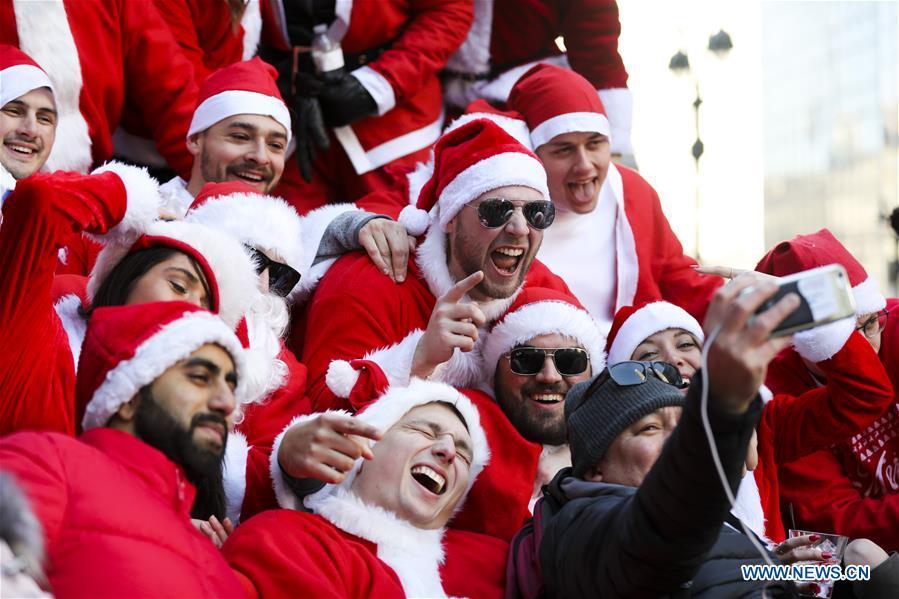 Revelers pose for photos during the 2018 SantaCon in New York, the United States, Dec. 8, 2018. Dressed as Santa Claus or in festive costumes, hundreds of People participated in the 2018 SantaCon on Saturday, enjoying the Christmas atmosphere and raising money for charity. (Xinhua/Wang Ying)