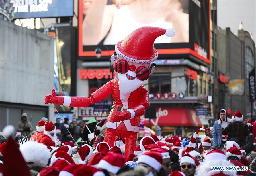 An inflatable Santa Claus is seen during the 2018 SantaCon in New York, the United States, Dec. 8, 2018. Dressed as Santa Claus or in festive costumes, hundreds of People participated in the 2018 SantaCon on Saturday, enjoying the Christmas atmosphere and raising money for charity. (Xinhua/Wang Ying)
