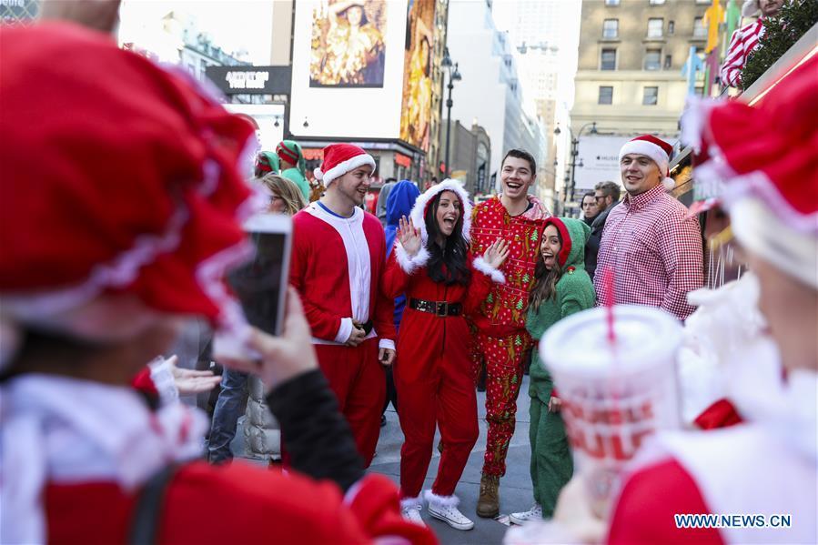 Revelers pose for photos during the 2018 SantaCon in New York, the United States, Dec. 8, 2018. Dressed as Santa Claus or in festive costumes, hundreds of People participated in the 2018 SantaCon on Saturday, enjoying the Christmas atmosphere and raising money for charity. (Xinhua/Wang Ying)
