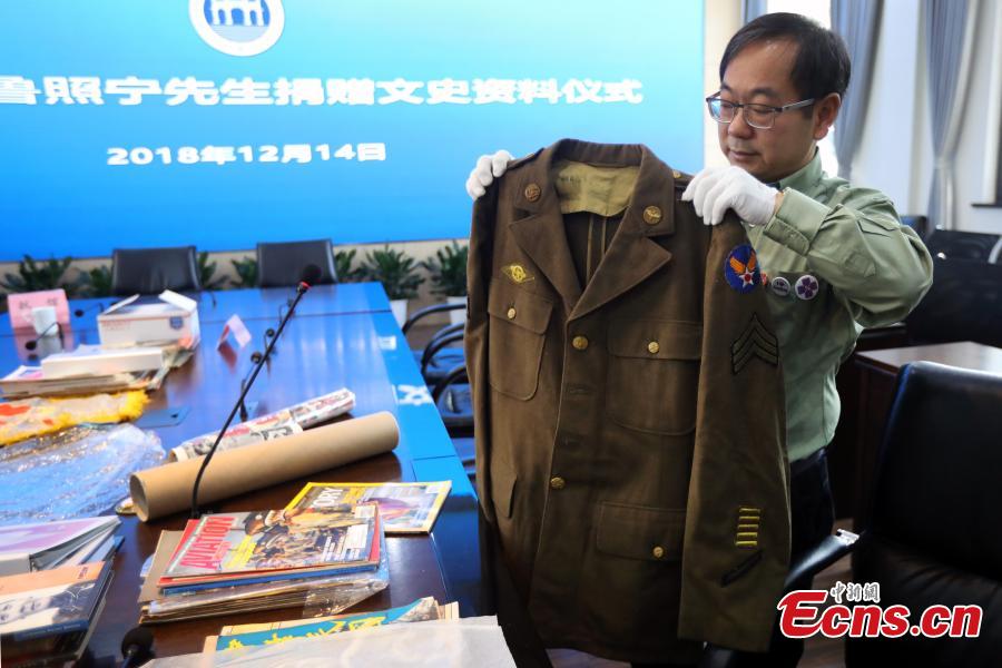Chinese-American Lu Zhaoning donates historical materials to the Memorial Hall of the Aviator Martyrs in the War of Resistance against Japanese Aggression in Nanjing City, Jiangsu Province, Dec. 14, 2018. The relics included pilot’s suits, books by Flying Tiger pilots and other materials about WWII war planes. Lu’s relative Lu Meiyin served as a flight attendant in the war. The memorial hall shows the names and a basic introduction in Chinese, English and Russian on thousands of pilots from China, the United States and Soviet Union who died in China during the war. (Photo: China News Service/Yang Bo)