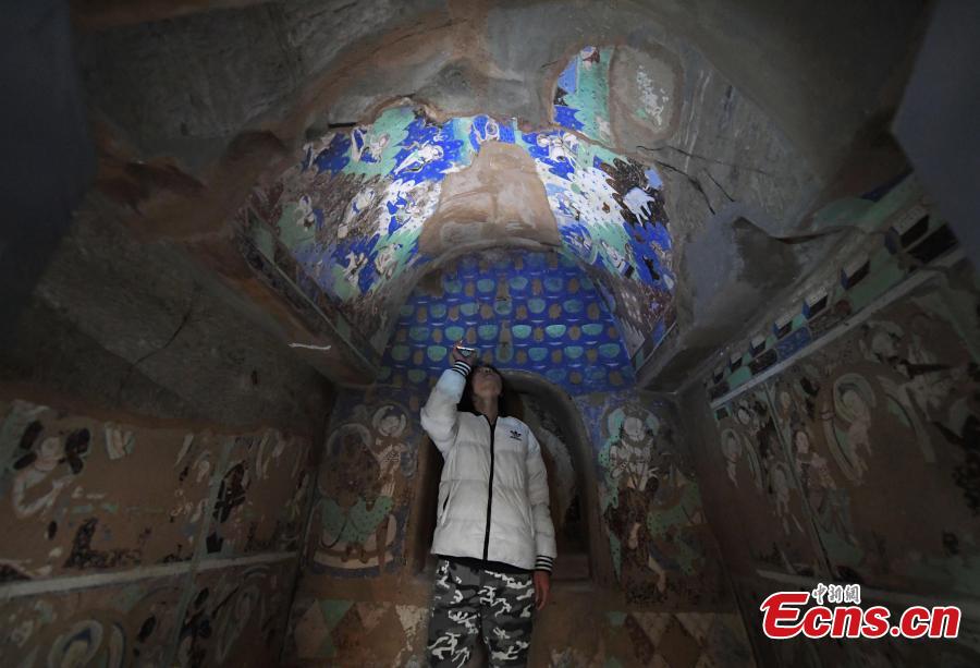 A visitor inside a life-size replica of a cave from the Kizil Caves in Northwest China’s Xinjiang Uygur Autonomous Region during an exhibition at Lanzhou University’s Yuzhong campus in Yuzhong County, Northwest China’s Gansu Province, December 13, 2018. Included in the exhibition were images of 137 murals, which were originally from the Kizil Caves but are now kept overseas, two replicas of original caves, and four digital caves. (Photo: China News Service/Yang Yanmin)