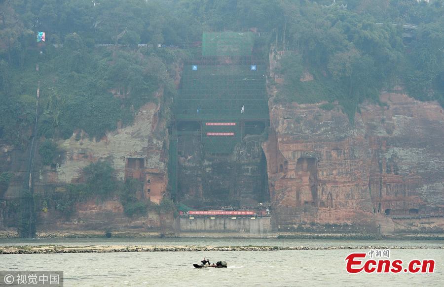 A 71-meter-tall Buddha statue-enclosed by scaffolding in the Leshan Giant Buddha Scenic Zone in Leshan, Sichuan province-has been undergoing repairs and maintenance since Oct 8. The price of entrance tickets to the scenic zone were cut by half on Monday because of the work, according to its administrative committee.(Photo/VCG)
