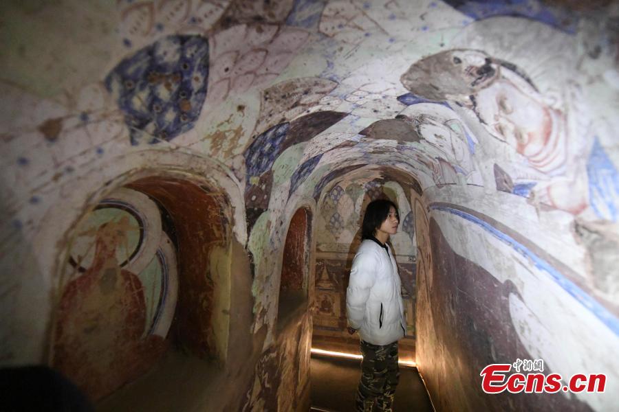 A visitor inside a life-size replica of a cave from the Kizil Caves in Northwest China’s Xinjiang Uygur Autonomous Region during an exhibition at Lanzhou University’s Yuzhong campus in Yuzhong County, Northwest China’s Gansu Province, December 13, 2018. Included in the exhibition were images of 137 murals, which were originally from the Kizil Caves but are now kept overseas, two replicas of original caves, and four digital caves. (Photo: China News Service/Yang Yanmin)