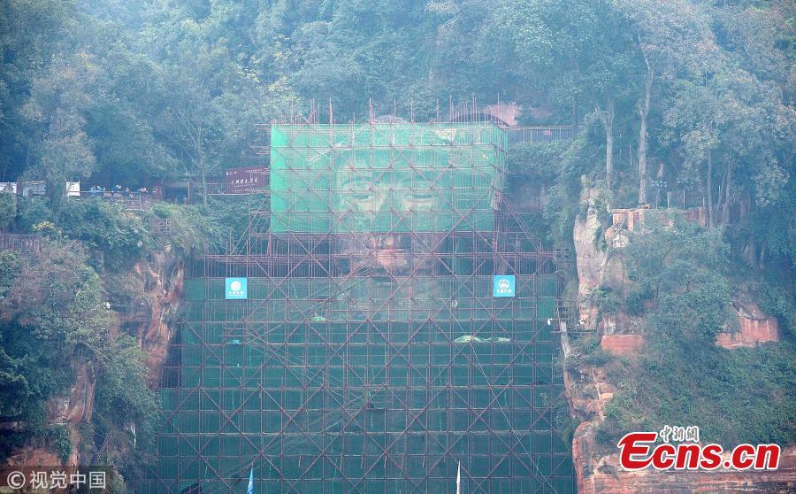 A 71-meter-tall Buddha statue-enclosed by scaffolding in the Leshan Giant Buddha Scenic Zone in Leshan, Sichuan province-has been undergoing repairs and maintenance since Oct 8. The price of entrance tickets to the scenic zone were cut by half on Monday because of the work, according to its administrative committee.(Photo/VCG)