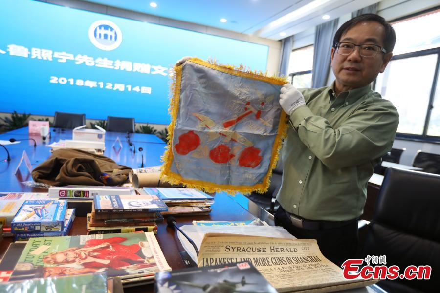 Chinese-American Lu Zhaoning donates historical materials to the Memorial Hall of the Aviator Martyrs in the War of Resistance against Japanese Aggression in Nanjing City, Jiangsu Province, Dec. 14, 2018. The relics included pilot’s suits, books by Flying Tiger pilots and other materials about WWII war planes. Lu’s relative Lu Meiyin served as a flight attendant in the war. The memorial hall shows the names and a basic introduction in Chinese, English and Russian on thousands of pilots from China, the United States and Soviet Union who died in China during the war. (Photo: China News Service/Yang Bo)