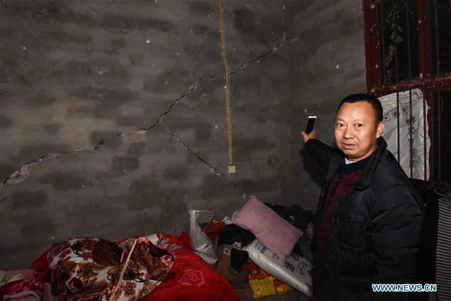 A villager shows a cracked wall in his home after a 5.7 magnitude earthquake in Luopu Village, Zhoujia Township of Xingwen County, southwest China\'s Sichuan Province, Dec. 16, 2018. China\'s emergency regulator on Sunday initiated a national emergency response to a magnitude 5.7 earthquake in southwest China\'s Sichuan Province. The earthquake hit the county of Xingwen in the city of Yibin, Sichuan Province, at 12:46 p.m. Sunday, with a depth of 12 km, according to the local government. By 5:30 p.m. Sunday, 16 people had been reported injured in the earthquake, the ministry said. (Xinhua/Zhang Kefan)