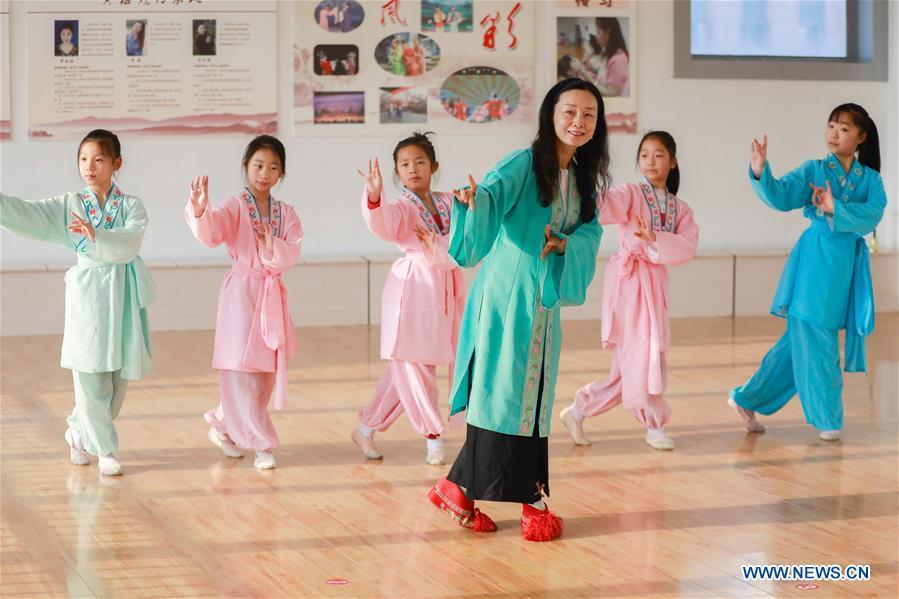 Meng Qingmei (3rd R), a performer of Xuyi Huangmei Opera Troupe, teaches students Huangmei Opera, in Xuyi County of east China\'s Jiangsu Province, Dec. 16, 2018. Performers of the troupe have been teaching local students Huangmei Opera in recent years to promote the traditional opera. (Xinhua/Zhou Haijun)