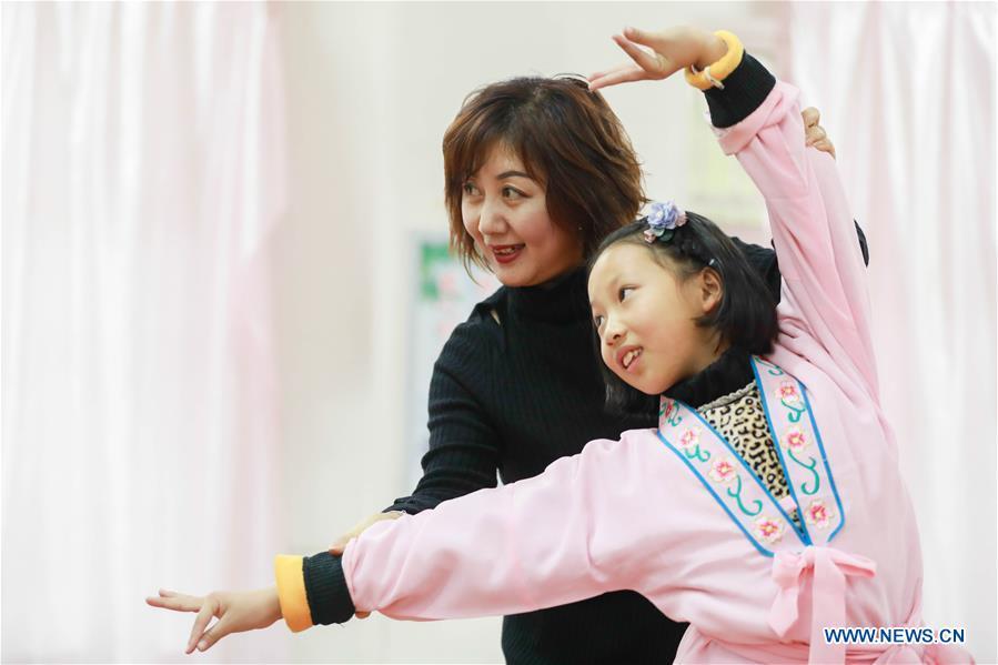 Bi Chunmei (L), a performer of Xuyi Huangmei Opera Troupe, teaches a student Huangmei Opera at Wudun Primary School, in Xuyi County of east China\'s Jiangsu Province, Dec. 16, 2018. Performers of the troupe have been teaching local students Huangmei Opera in recent years to promote the traditional opera. (Xinhua/Zhou Haijun)