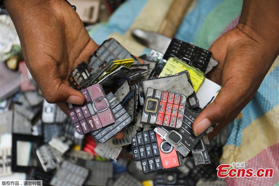 Desire Koffi, 24-year-old artist, holds discarded phone keyboards at his workshop in Abidjan, Ivory Coast Nov. 30, 2018. Desire Koffi often walks through Koumassi, a popular district of Ivory Coast\'s main city Abidjan, to collect old mobile phones that he buys from people for 500 CFA francs ($0.8726) a pair. Back home, he dismantles the phones with a hammer to pull out the screens and keyboards. He uses them for his paintings. One can take him up to three or five days of work. (Photo/Agencies)