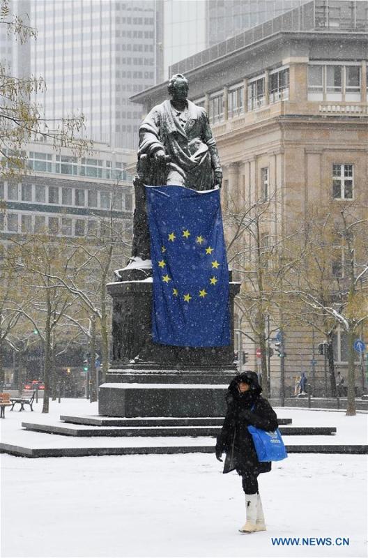 A woman walks past the snow-covered Goethe Plaza in Frankfurt, Germany, on Dec. 16, 2018. A snowfall hit Frankfurt on Sunday. (Xinhua/Lu Yang)