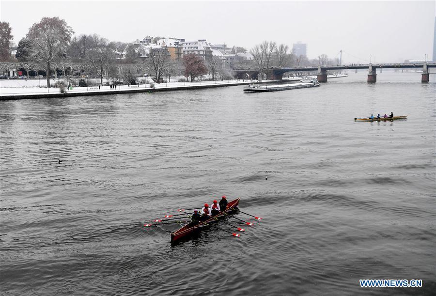 People paddle along the Main River in Frankfurt, Germany, on Dec. 16, 2018. A snowfall hit Frankfurt on Sunday. (Xinhua/Lu Yang)