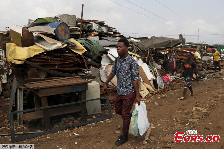 Desire Koffi, 24-year-old artist, walks at a recycling area in search of old mobile phones in Abidjan, Ivory Coast, Nov. 30, 2018. Desire Koffi often walks through Koumassi, a popular district of Ivory Coast\'s main city Abidjan, to collect old mobile phones that he buys from people for 500 CFA francs ($0.8726) a pair. Back home, he dismantles the phones with a hammer to pull out the screens and keyboards. He uses them for his paintings. One can take him up to three or five days of work. (Photo/Agencies)