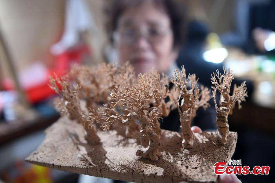 Folk artist Chen Xuerong, who has practiced the craft for 60 years, carves on bark at a workshop in Fuzhou City, East China\'s Fujian Province. As an intangible cultural heritage, bark carving is regarded as one of the three treasures of Fujian. Craftsmen can carve elaborate scenes, including pavilions, bridges and landscape features, onto the bark. The craft is in decline today as fewer young people are interested in the time-consuming profession. (Photo: China News Service/Zhang Bin)
