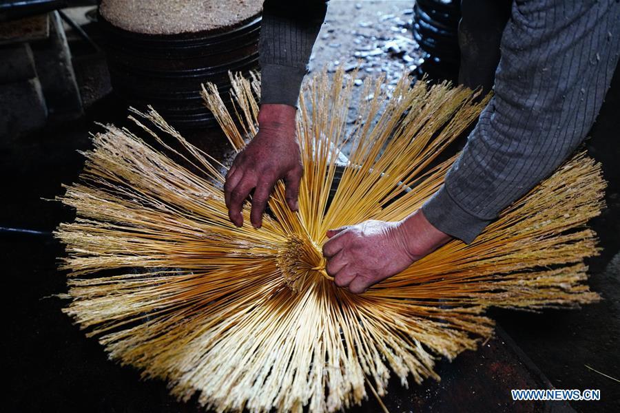 Yang Qiqing, a 68-year-old villager, ties up straws to extract camellia oil, also known as tea seed oil, in Licha Village of Longsheng County, south China\'s Guangxi Zhuang Autonomous Region, Dec. 17, 2018. Camellia oil made with traditional methods by workshops in the village is quite popular in market because of its better quality and longer guarantee. (Xinhua/Huang Yongdan)