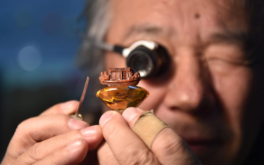 Han Zhiyao cleans up his work The Nut-carving Boat at his studio in Dalian, Liaoning Province, on Dec. 12, which reproduce the nut carving work recorded in the article The Nut-carving Boat in the Ming Dynasty (1368-1644). (Photo/Xinhua)
Dalian nut carving, which involves turning the cores of walnuts into artworks, is an ancient folk art based on traditional meticulous sculpture. It was listed as one of China\'s national intangible cultural heritage in 2014.
Han Zhiyao, 62-year-old inheritor of Dalian nut carving, has learned the skill since childhood. Familiar folk stories and historical allusions are reproduced in the small nuts through his skillful hands.
In recent years, Han Zhiyao has been trying to incorporate more traditional cultural elements into nut carving. He hopes to create more works in his lifetime so that this skill can reach the world.