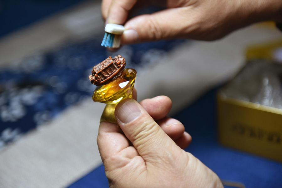Han Zhiyao cleans up his work The Nut-carving Boat at his studio in Dalian, Liaoning Province, on Dec. 12, which reproduce the nut carving work recorded in the article The Nut-carving Boat in the Ming Dynasty.