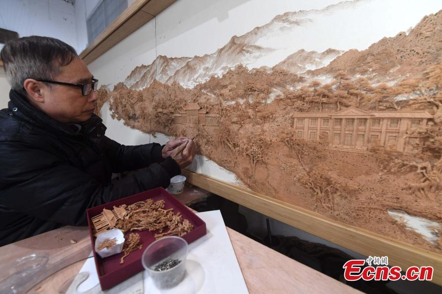 A craftsman carves on bark at a workshop in Fuzhou City, East China\'s Fujian Province. As an intangible cultural heritage, bark carving is regarded as one of the three treasures of Fujian. Craftsmen can carve elaborate scenes, including pavilions, bridges and landscape features, onto the bark. The craft is in decline today as fewer young people are interested in the time-consuming profession. (Photo: China News Service/Zhang Bin)
