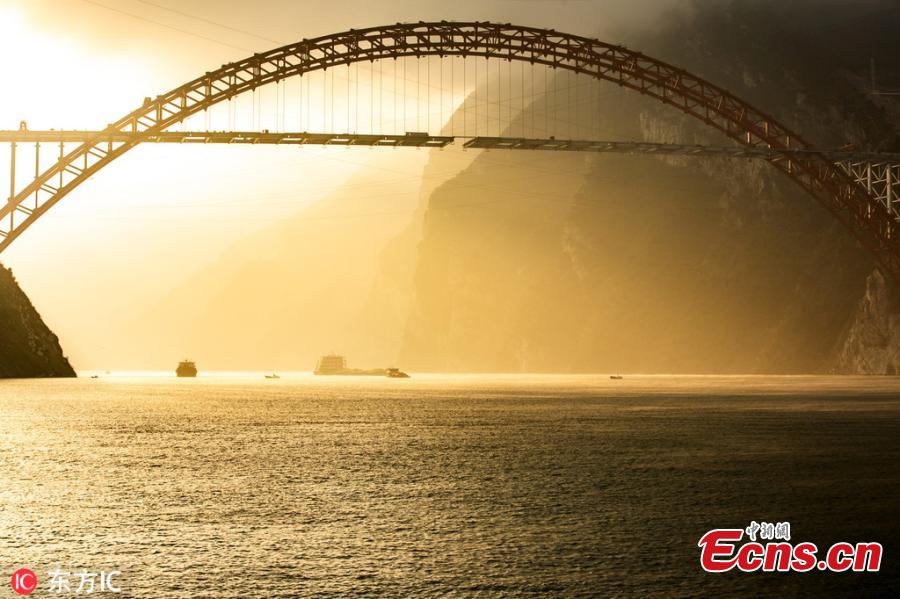 Sunrise at the construction site of a bridge over the Yangtze River in Zigui County, Central China\'s Hubei Province. The confluence of Xiangxi Stream, a tributary of China\'s greatest river, and Xiling Gorge, one of the Three Gorges, is a tourist attraction renowned for its magnificent scenic beauty. (Photo/IC)