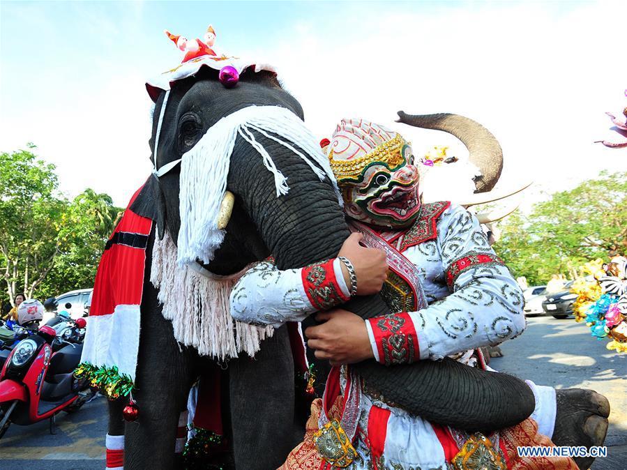 A man poses for photos with an elephant during Christmas celebrations at a school in Ayutthaya province, Thailand, Dec. 24, 2018. The annual event is held to celebrate Christmas and promote tourism in Ayutthaya. (Xinhua/Rachen Sageamsak)
