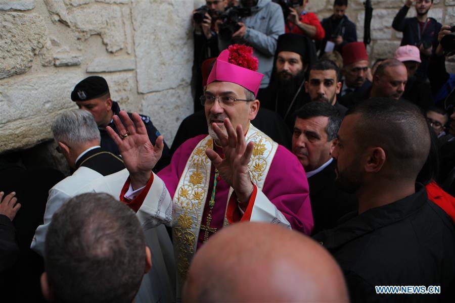 The acting Apostolic Administrator of Jerusalem, Pierbattista Pizzaballa (C), enters the Church of the Nativity in the West Bank city of Bethlehem on Dec. 24, 2018. Thousands of Christian pilgrims gathered in Bethlehem\'s Manger Square to celebrate Christmas. (Xinhua/Mamoun Wazwaz)