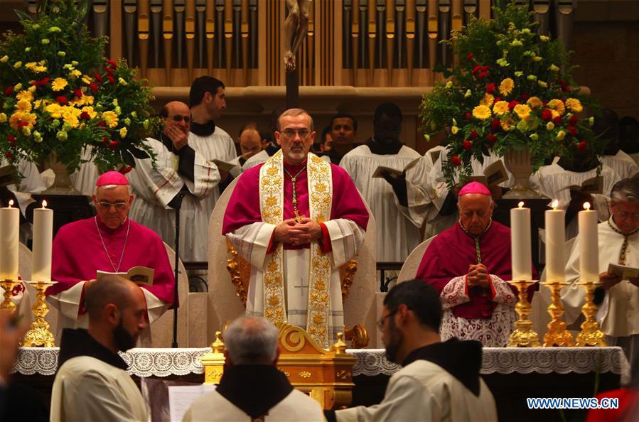 The acting Apostolic Administrator of Jerusalem, Pierbattista Pizzaballa (C), attends a mass on Christmas Eve inside the Church of the Nativity in the West Bank city of Bethlehem on Dec. 24, 2018. Thousands of Christian pilgrims gathered in Bethlehem\'s Manger Square to celebrate Christmas. (Xinhua/Mamoun Wazwaz)