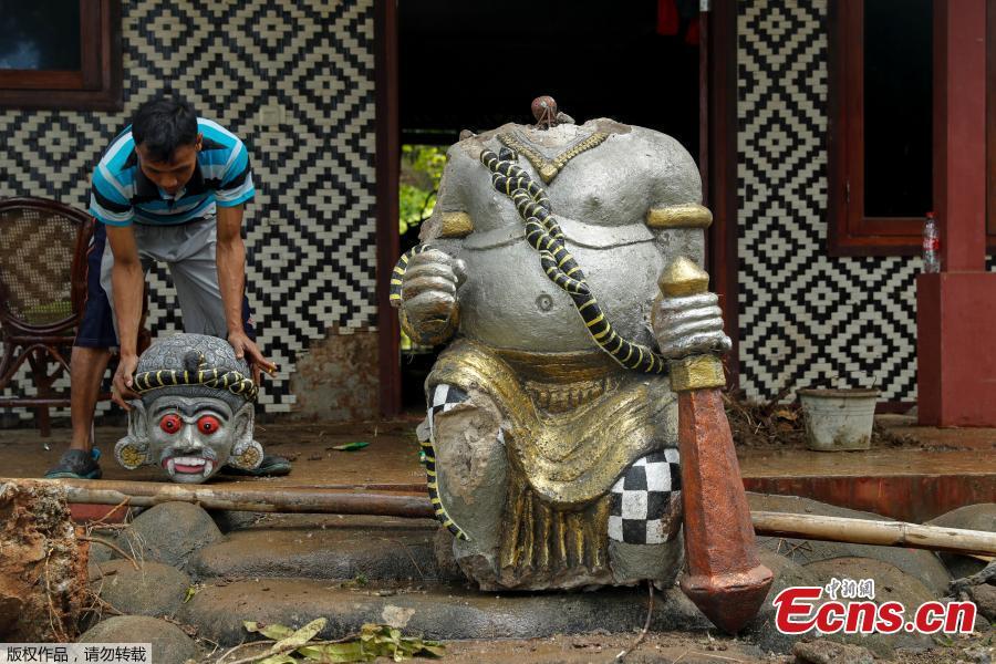 A worker lifts up a head of destroyed statue at the beach front hotel which was hit by a tsunami in Pandeglang, Banten province, Indonesia, Dec. 24, 2018. Indonesian military and rescue teams fanned out across a stretch of coastline on Monday, hoping to find survivors of a tsunami triggered by a landslide from a volcano that killed at least 373 people. (Photo/Agencies)