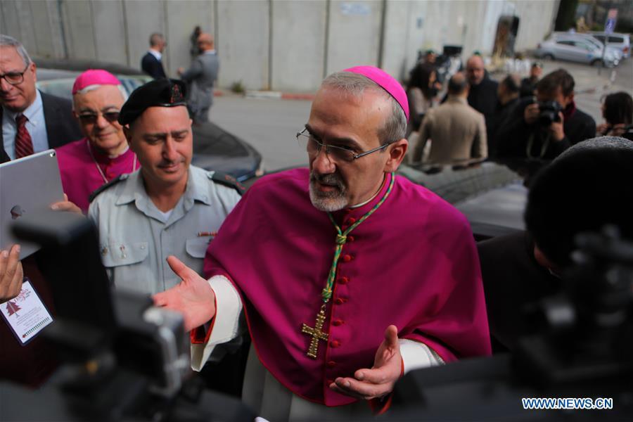 The acting Apostolic Administrator of Jerusalem, Pierbattista Pizzaballa (C), enters the Church of the Nativity in the West Bank city of Bethlehem on Dec. 24, 2018. Thousands of Christian pilgrims gathered in Bethlehem\'s Manger Square to celebrate Christmas. (Xinhua/Mamoun Wazwaz)