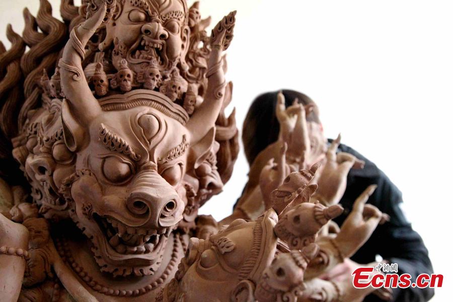 A folk artist creates a clay sculpture in Regong, Tongren County, Huangnan Tibetan Autonomous Prefecture, Qinghai Province, Dec. 25, 2018. Buddhist monks and folk artists carry on the plastic arts of painting thangka and murals, crafting patchwork barbola and sculpting known collectively as the Regong arts, inscribed on the representative list of the UNESCO Intangible Cultural Heritage of Humanity. (Photo: China News Service/Zhang Tianfu)