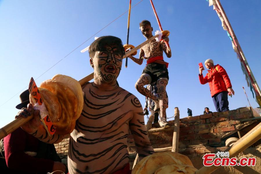 People of the Tu ethnic group perform the Wutu dance during a ceremony at Nianduhu village in Tongren County, Northwest China\'s Qinghai Province, December 26, 2018. The annual ceremony is held, between Nov. 5 to 20 in the lunar calendar, to dispel disease and exorcise evils. In ancient Chinese dialects, \