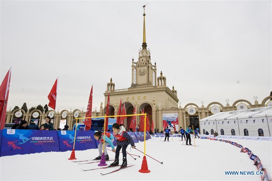 File photo taken on Dec. 22, 2018 shows children ski during the opening ceremony for China Winter Sports Festival in front of Beijing Exhibition Center in Beijing, capital of China. August 8 marked China\'s 10th National Fitness Day, a celebration of the expanded fitness options for the public and ever-greater acceptance of the country\'s national fitness efforts. Winter sports has also seen a big boost in the past year, especially in southern and eastern China.(Xinhua/Wang Jingsheng)