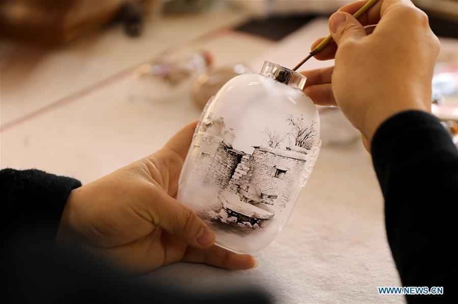 Yin Jianqing shows the inner painting technique at Hebei College of Industry and Technology in Shijiazhuang, north China\'s Hebei Province, Dec. 28, 2018. The college takes intangible cultural heritages such as techniques of pyrograph and inner painting into school courses in recent years. (Xinhua/Liang Zidong)