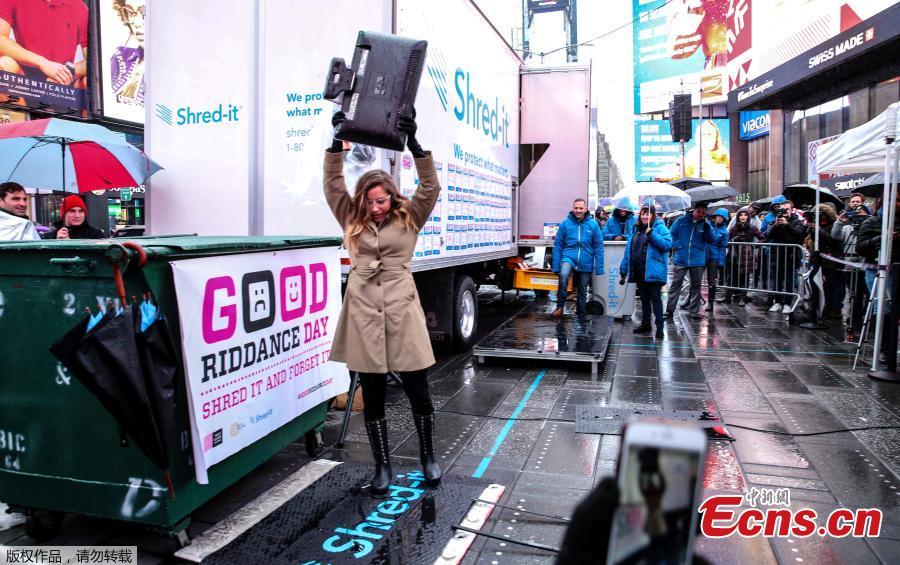 Allison Hagendorf mashes computer parts with a hammer during the National Good Riddance day ceremonial shredding of bad memories of 2018 in Times Square in the Manhattan borough of New York, U.S., Dec. 28, 2018. (Photo/Agencies)