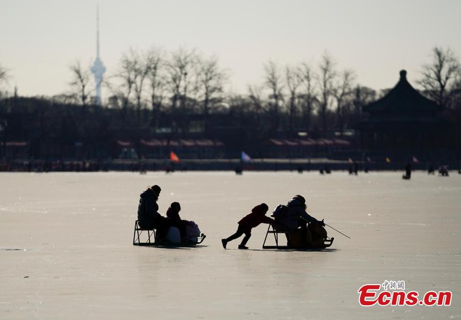 People have fun on the frozen Kunming Lake at the Summer Palace in Beijing, Dec. 30, 2018. With an area of 700,000 square meters, Kunming Lake is the largest natural ice rink in winter in Beijing.The ice rink was open to the public on Sunday. (Photo: China News Service/Du Yang)