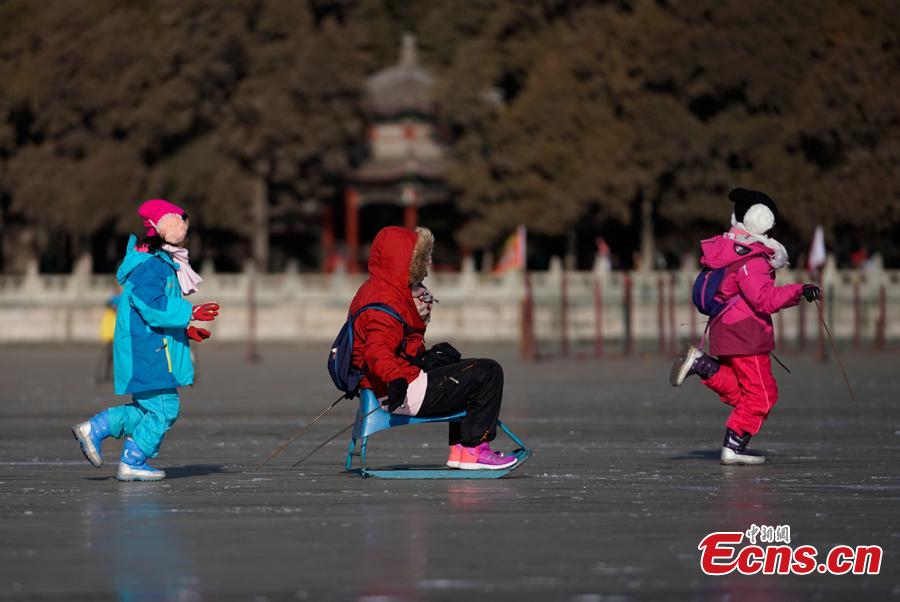 People have fun on the frozen Kunming Lake at the Summer Palace in Beijing, Dec. 30, 2018. With an area of 700,000 square meters, Kunming Lake is the largest natural ice rink in winter in Beijing.The ice rink was open to the public on Sunday. (Photo: China News Service/Du Yang)