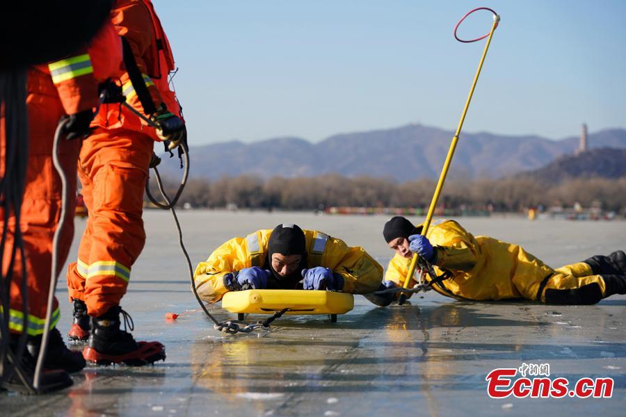Workers have a rescue drill on the frozen Kunming Lake at the Summer Palace in Beijing, Dec. 30, 2018. With an area of 700,000 square meters, Kunming Lake is the largest natural ice rink in winter in Beijing.The ice rink was open to the public on Sunday. (Photo: China News Service/Du Yang)