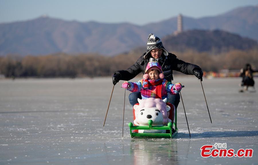 People have fun on the frozen Kunming Lake at the Summer Palace in Beijing, Dec. 30, 2018. With an area of 700,000 square meters, Kunming Lake is the largest natural ice rink in winter in Beijing.The ice rink was open to the public on Sunday. (Photo: China News Service/Du Yang)