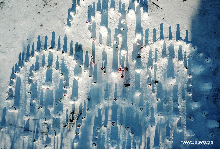 Aerial photo taken on Jan. 2, 2019 shows people viewing snowman sculptures on the riverbank of Songhua River in Harbin, capital of northeast China\'s Heilongjiang Province. Altogether 2,019 cute snowmen were displayed here to greet the year 2019. (Xinhua/Wang Jianwei)