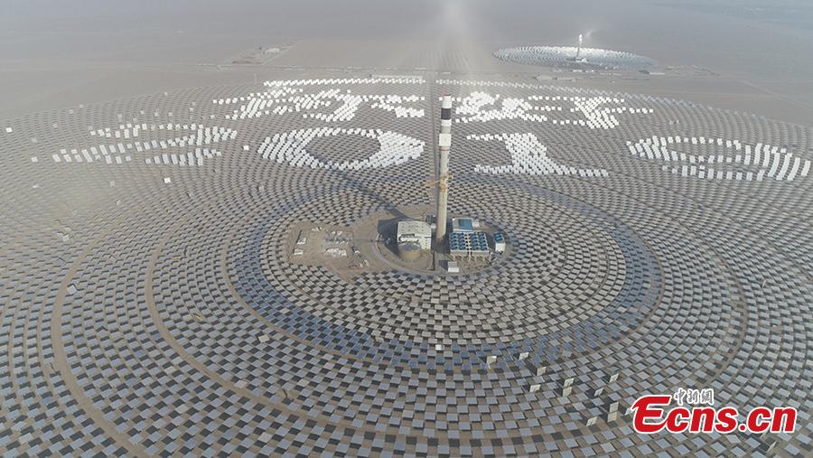 Mirrors are arranged to form New Year greetings in Chinese at a 100-megawatt molten-salt solar thermal power plant in Dunhuang City, Northwest China’s Gansu Province, Jan. 1, 2019. The plant is powered by 12,000 mirrors that concentrate sunlight onto a receiver at the top of a solar tower, 260 meters high. The heat collected is used to create steam that turns a turbine and generator, as at a traditional thermal power plant. The molten salt can also be stored and used to generate power on demand, even at night. (Photo: China News Service/Zhou Binquan)