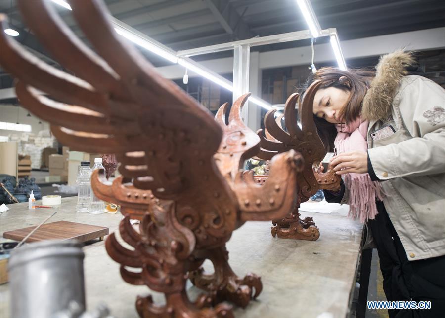 A craftswoman checks copper artwork at a factory workshop in Jiande City, east China\'s Zhejiang Province, Jan. 2, 2019. A traditional sanitary ware production company, Tong Shifu, meaning Copper Master, has converted itself into an enterprise that designs and makes copper artwork in collaboration with museum, cartoon firm and artist\'s studio. With the annual output reaching 500 million yuan (about 72.9 million U.S. dollars), the company has succeeded in industrial transformation. (Xinhua/Weng Xinyang)