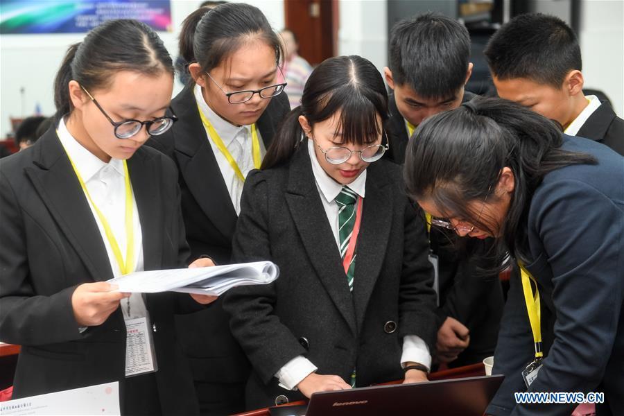 Students discuss during the 8th Model UN conference for middle school students in Hefei, capital of east China\'s Anhui Province, Nov. 17, 2018. China\'s primary and middle schools have been urged to improve education for all-around student development, according to a directive issued by authorities. Jointly issued by the Ministry of Education and other eight agencies, the circular asked schools to offer courses that are in accord with the national syllabus in terms of their quantity and quality. The enhancement of courses\' difficulty levels and speed at random and in disregard of the curriculum is prohibited, according to the circular. Primary and junior middle schools are not allowed to set up any \